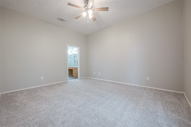 empty room featuring carpet flooring, ceiling fan, and a textured ceiling