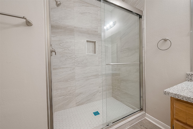 bathroom with vanity and a shower with door