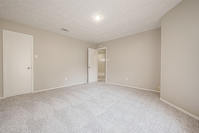 carpeted empty room featuring a textured ceiling