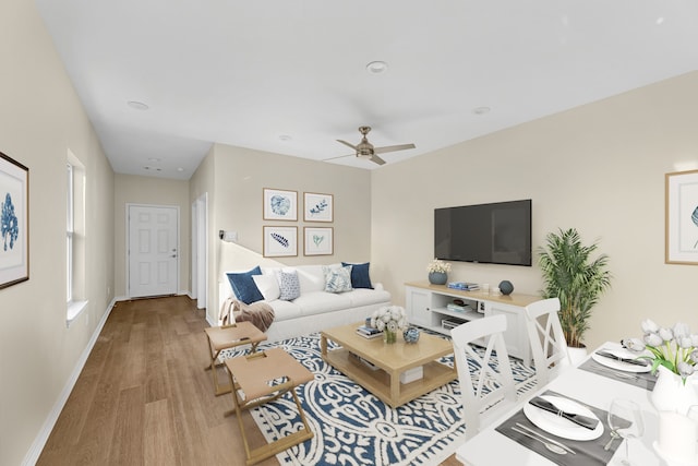 living room featuring ceiling fan and light hardwood / wood-style flooring