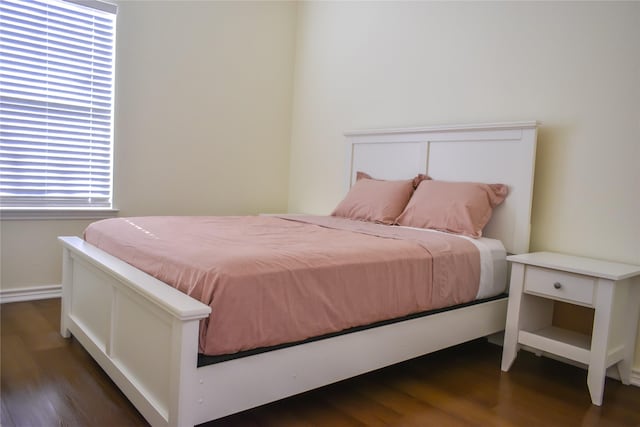 bedroom with dark hardwood / wood-style floors