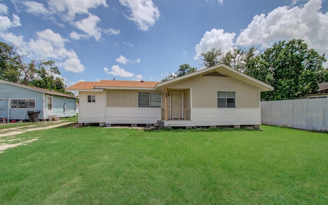 rear view of house featuring a yard