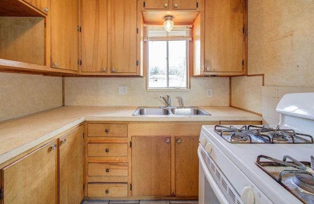 kitchen featuring tasteful backsplash, sink, and white gas range oven