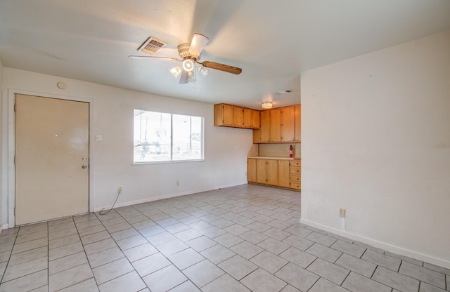 unfurnished living room featuring ceiling fan and light tile patterned flooring