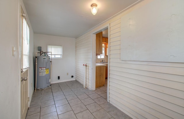 laundry room with hookup for an electric dryer, ornamental molding, sink, water heater, and light tile patterned flooring