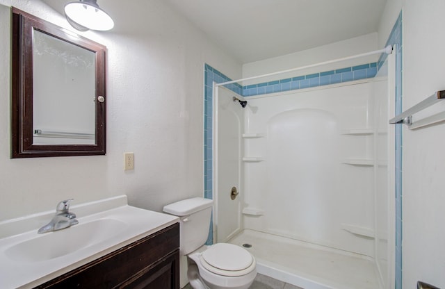 bathroom featuring a shower, vanity, and toilet