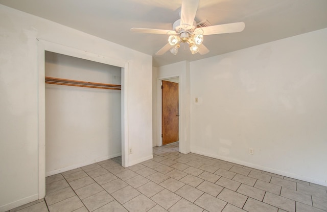 unfurnished bedroom with ceiling fan and a closet