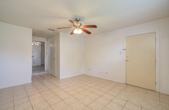 tiled empty room featuring ceiling fan