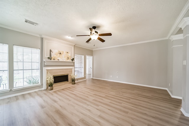 unfurnished living room featuring hardwood / wood-style flooring, ceiling fan, crown molding, and a textured ceiling