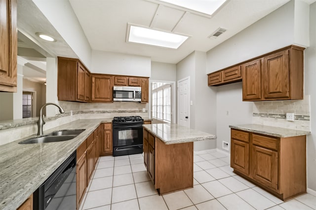 kitchen with light stone countertops, backsplash, sink, black appliances, and light tile patterned floors