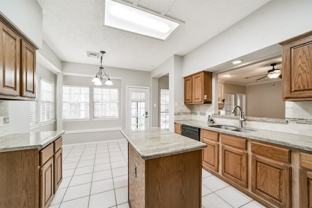 kitchen with dishwasher, a center island, backsplash, ceiling fan with notable chandelier, and sink