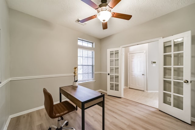 home office with french doors, a textured ceiling, light hardwood / wood-style flooring, and ceiling fan