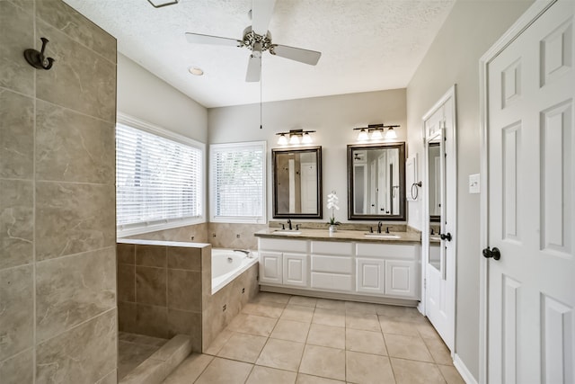 bathroom featuring tile patterned floors, vanity, a textured ceiling, ceiling fan, and shower with separate bathtub