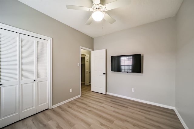 unfurnished bedroom with a closet, light hardwood / wood-style floors, and ceiling fan