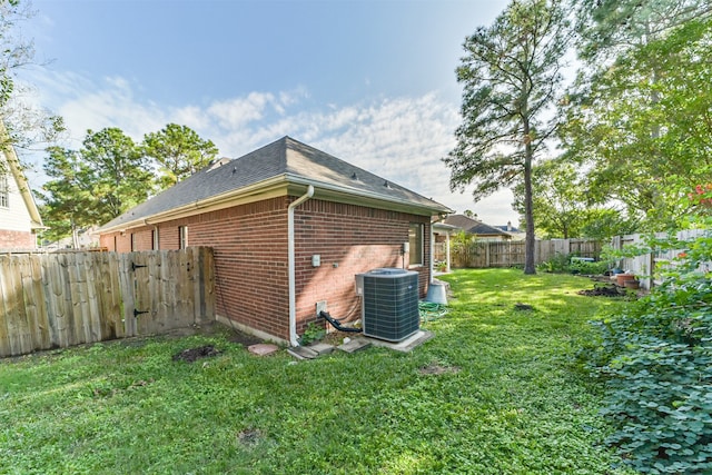 view of side of home featuring central AC unit and a lawn