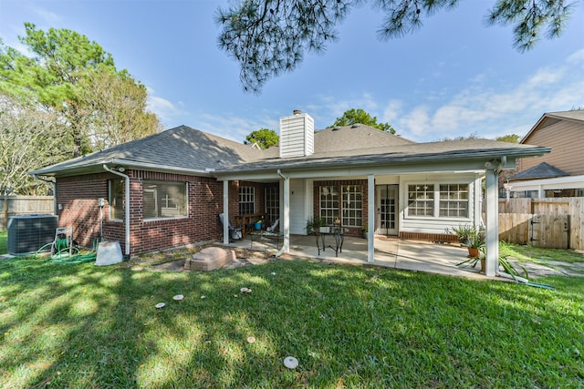 back of property featuring central air condition unit, a yard, and a patio