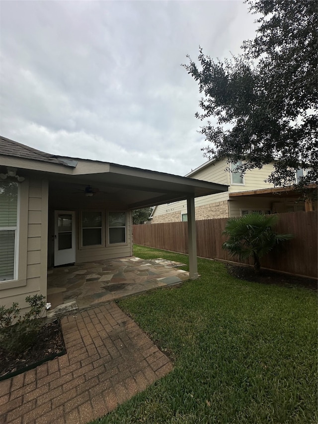 view of yard featuring ceiling fan and a patio area