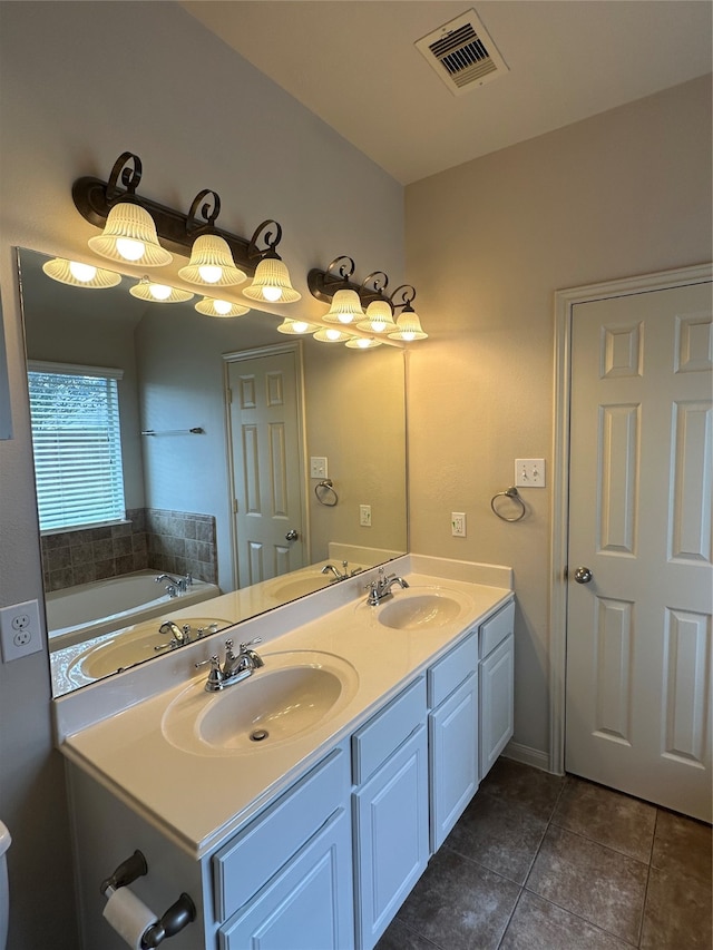 bathroom with tile patterned flooring, vanity, and a bathing tub