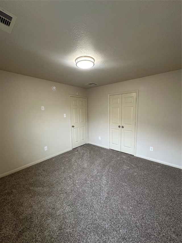 empty room featuring carpet and a textured ceiling