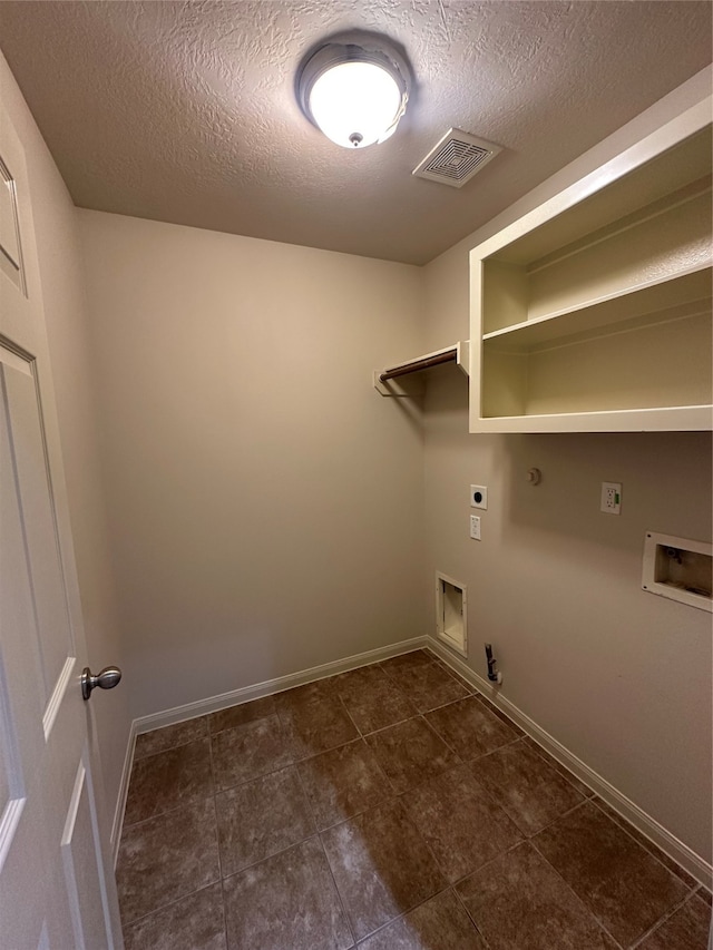 clothes washing area with hookup for a washing machine, a textured ceiling, hookup for a gas dryer, and electric dryer hookup