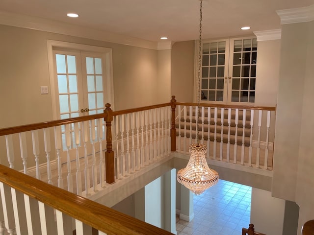 corridor with an inviting chandelier, ornamental molding, and french doors