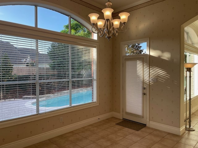 interior space featuring crown molding, light tile patterned flooring, and a chandelier