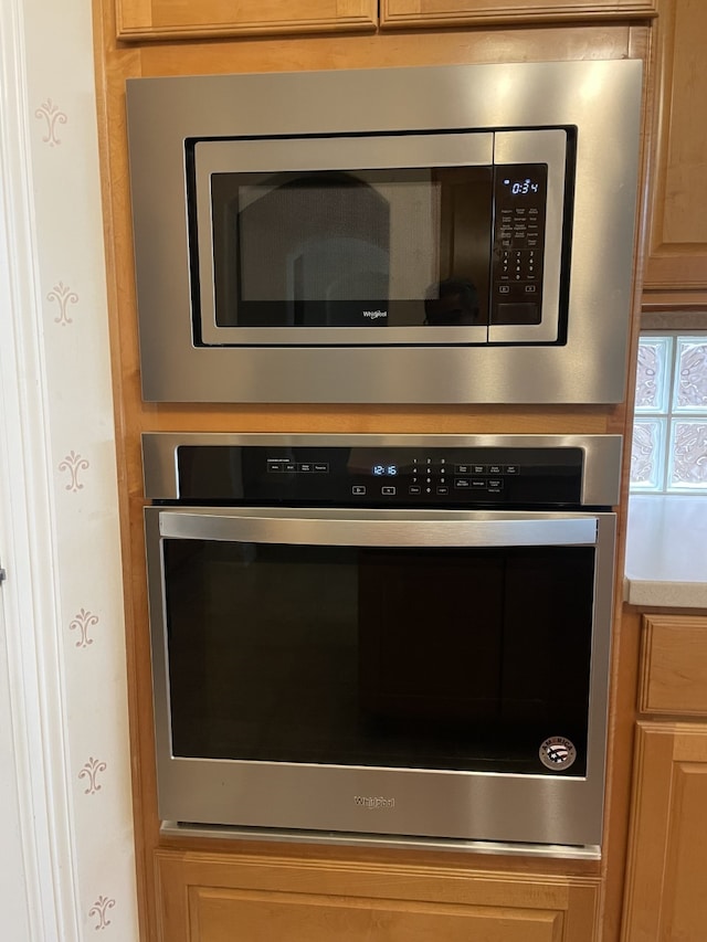 interior details with appliances with stainless steel finishes and light brown cabinetry