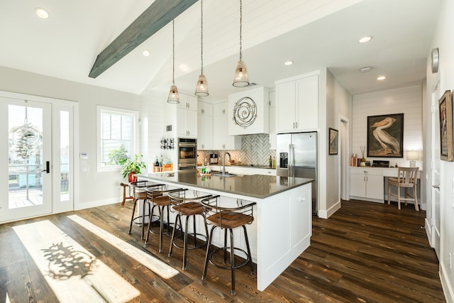 kitchen with pendant lighting, dark hardwood / wood-style floors, white cabinetry, and lofted ceiling