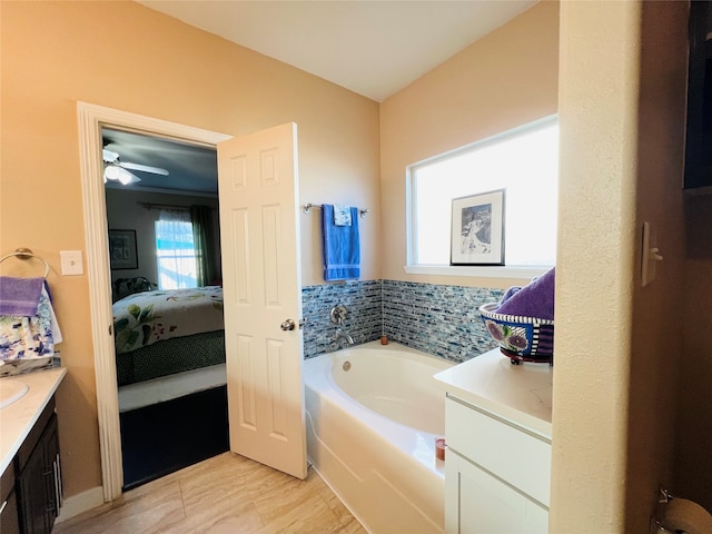 bathroom with a bathing tub, vanity, and ceiling fan