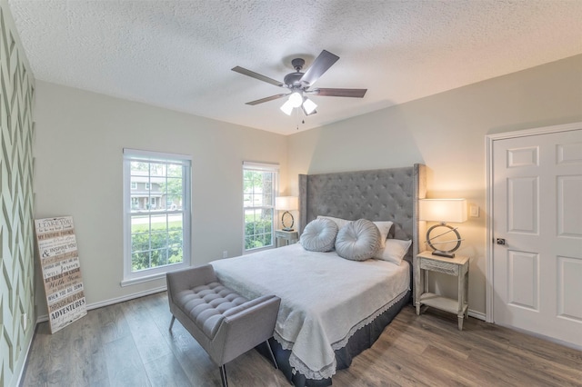 bedroom featuring a textured ceiling, ceiling fan, and dark wood-type flooring