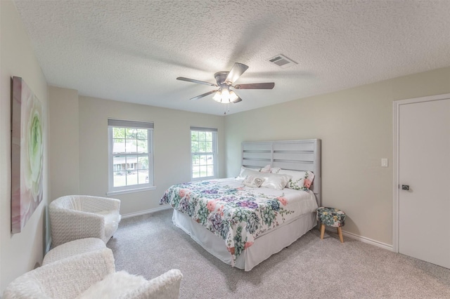 carpeted bedroom with a textured ceiling and ceiling fan