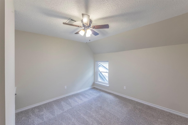 carpeted empty room with a textured ceiling, ceiling fan, and vaulted ceiling