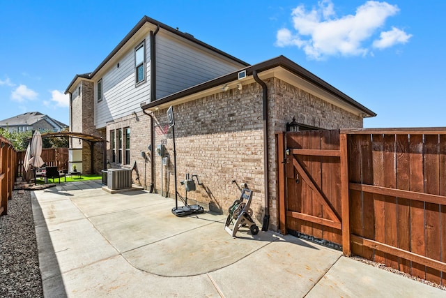 rear view of property with central AC and a patio area