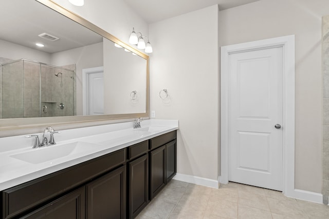 bathroom featuring tile patterned floors, vanity, and a shower with door