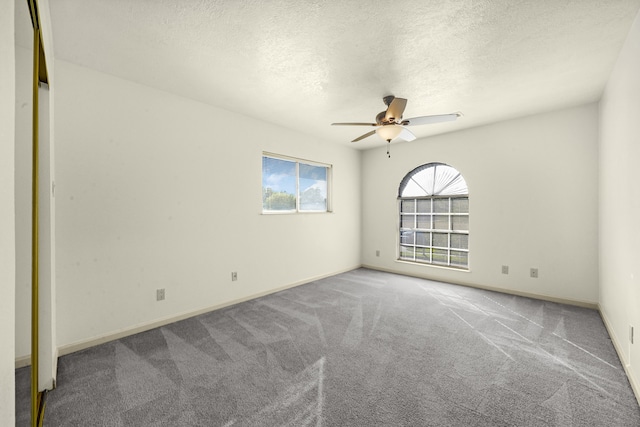 unfurnished room featuring ceiling fan, carpet floors, and a textured ceiling