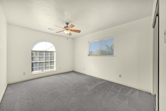 carpeted empty room with a textured ceiling and ceiling fan