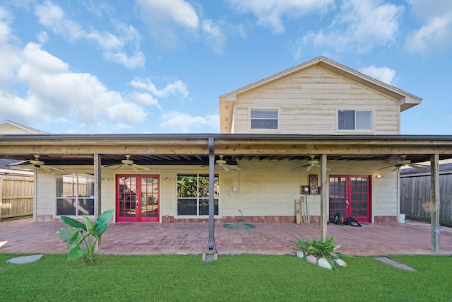 rear view of house featuring a lawn, a patio, and french doors