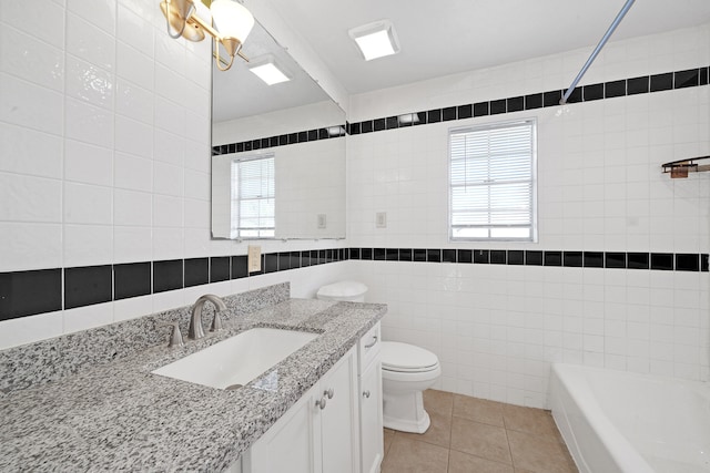 bathroom with tile patterned flooring, vanity, tile walls, and toilet