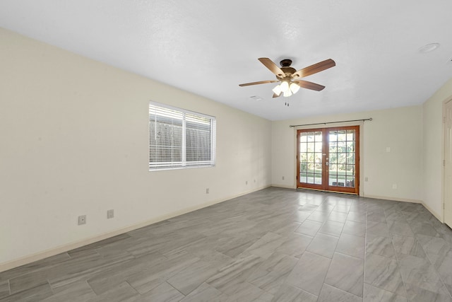 empty room with ceiling fan and french doors