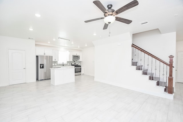 unfurnished living room with ceiling fan and sink