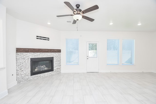 unfurnished living room with a fireplace, light hardwood / wood-style flooring, and ceiling fan