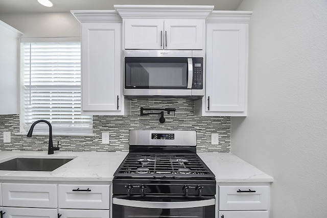 13754 Lynx Dr, Houston, TX 77014 - kitchen featuring stainless steel appliances, a sink, backsplash, and white cabinetry