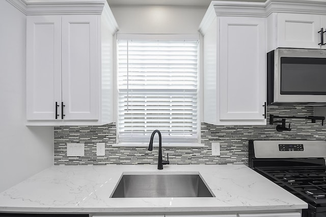13754 Lynx Dr, Houston, TX 77014 - kitchen featuring stainless steel appliances, a sink, tasteful backsplash, white cabinets, and plenty of natural light