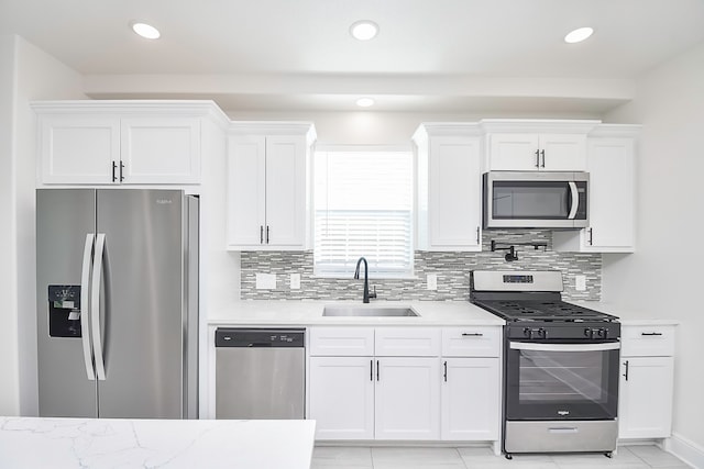 kitchen with sink, white cabinets, and stainless steel appliances