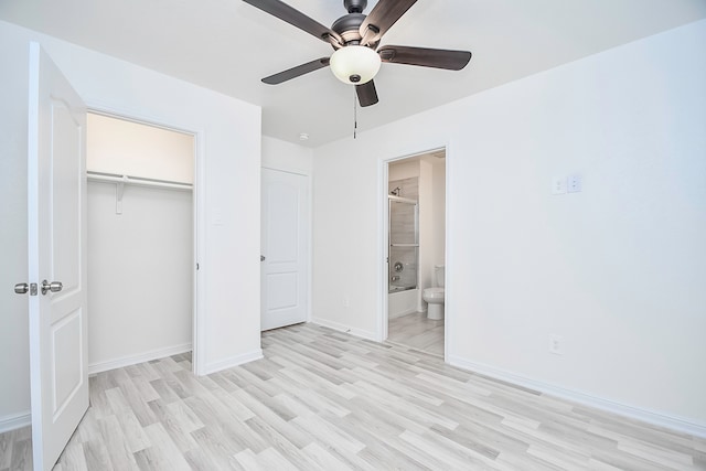 unfurnished bedroom featuring ceiling fan, light hardwood / wood-style floors, ensuite bathroom, and a closet