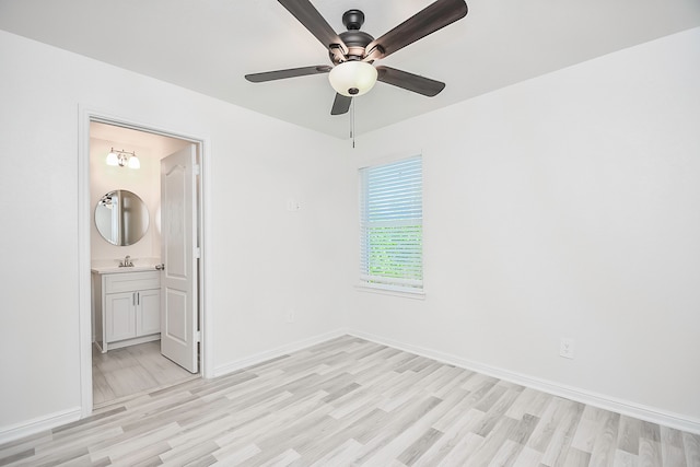 unfurnished bedroom with ensuite bath, ceiling fan, sink, and light wood-type flooring