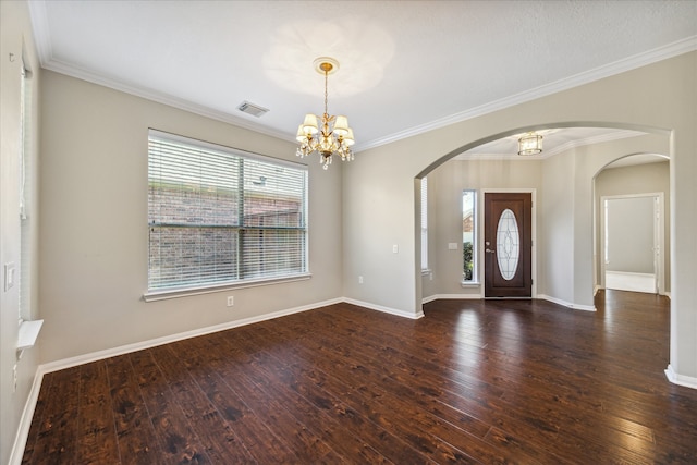 foyer entrance featuring a notable chandelier, dark hardwood / wood-style flooring, and ornamental molding