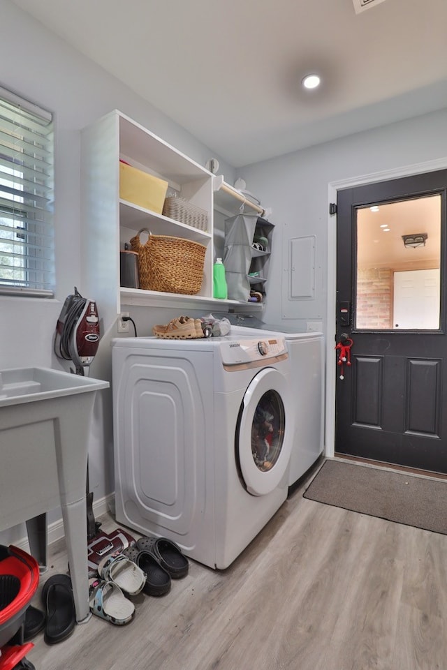 laundry area featuring washing machine and clothes dryer and light wood-type flooring