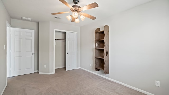 unfurnished bedroom with ceiling fan, a closet, and light carpet