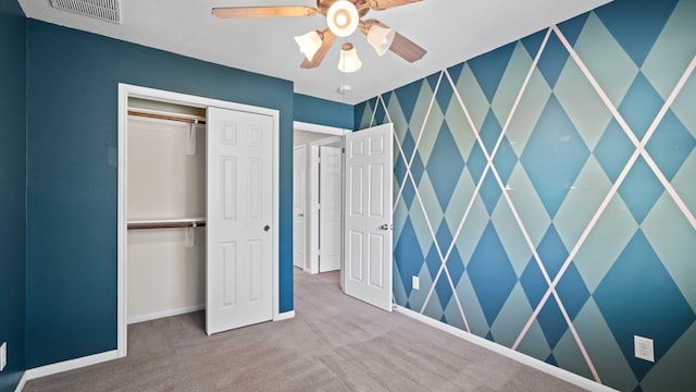 unfurnished bedroom with carpet flooring, ceiling fan, and a closet